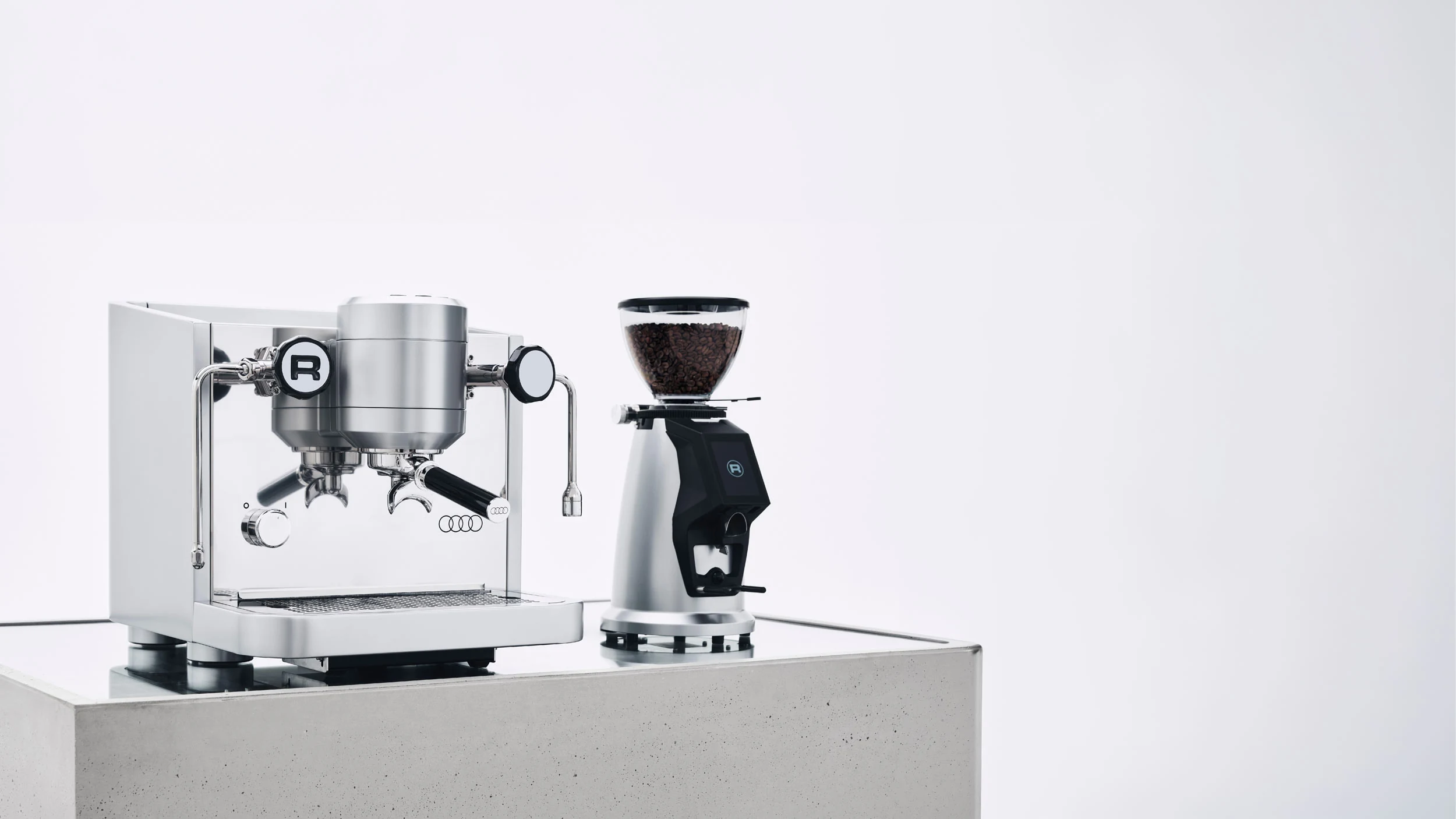 Rocket × Audi espresso machine and grinder on a concrete display plinth