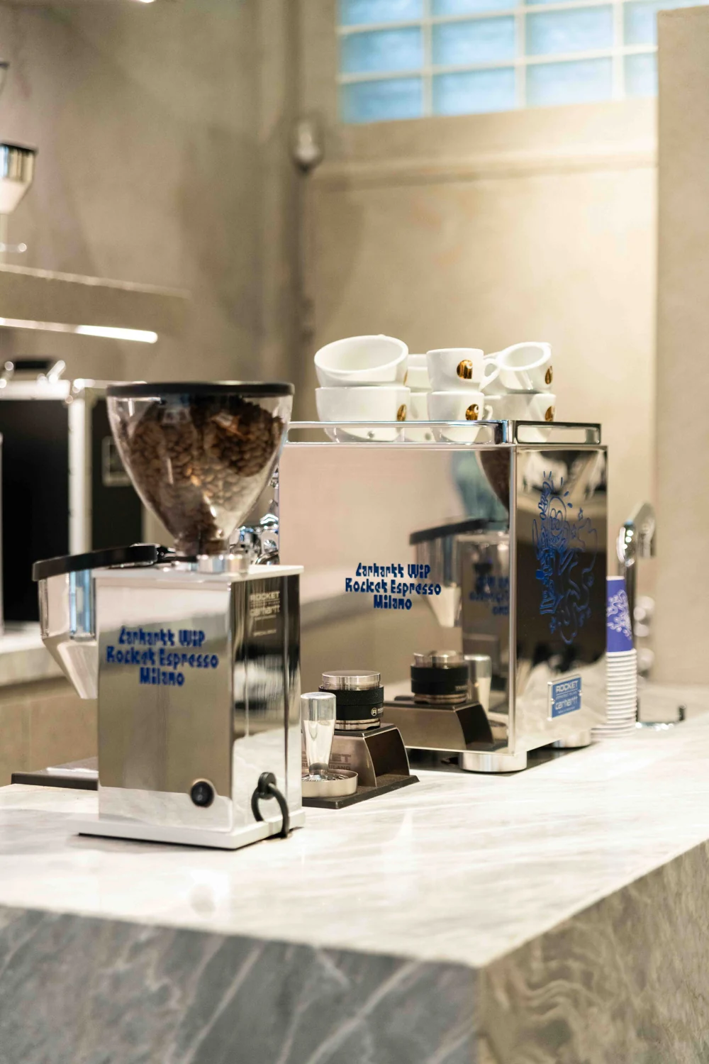 Silver Carhartt WIP × Rocket Espresso machine and grinder displayed together at the Milan launch