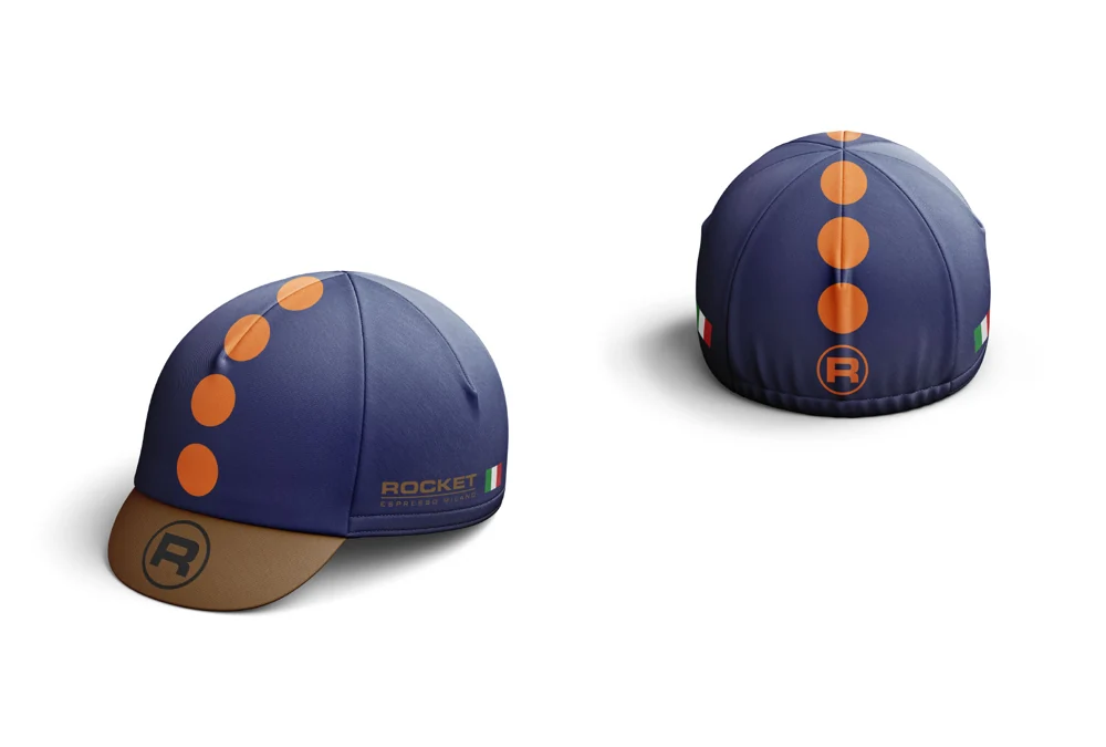 Two views of a navy Rocket cycling cap with orange circles and an ochre peak
